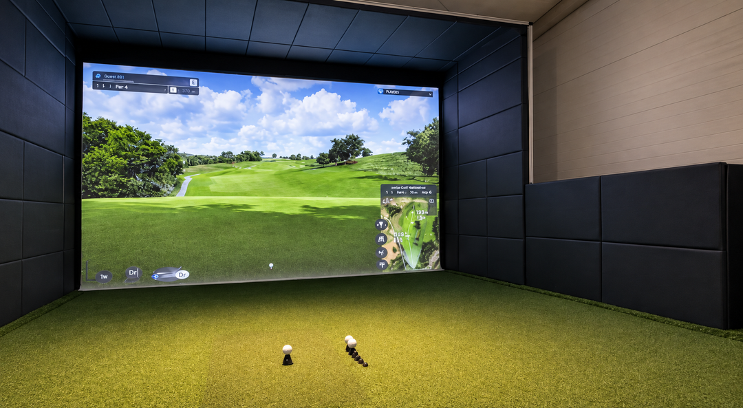 Écran de simulateur affichant un parcours de golf, entouré de panneaux de protection en mousse et de gazon intérieur