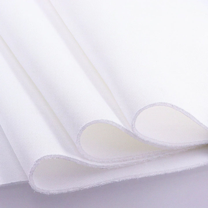 Close-up of white golf impact screen fabric folded to show its texture and thickness