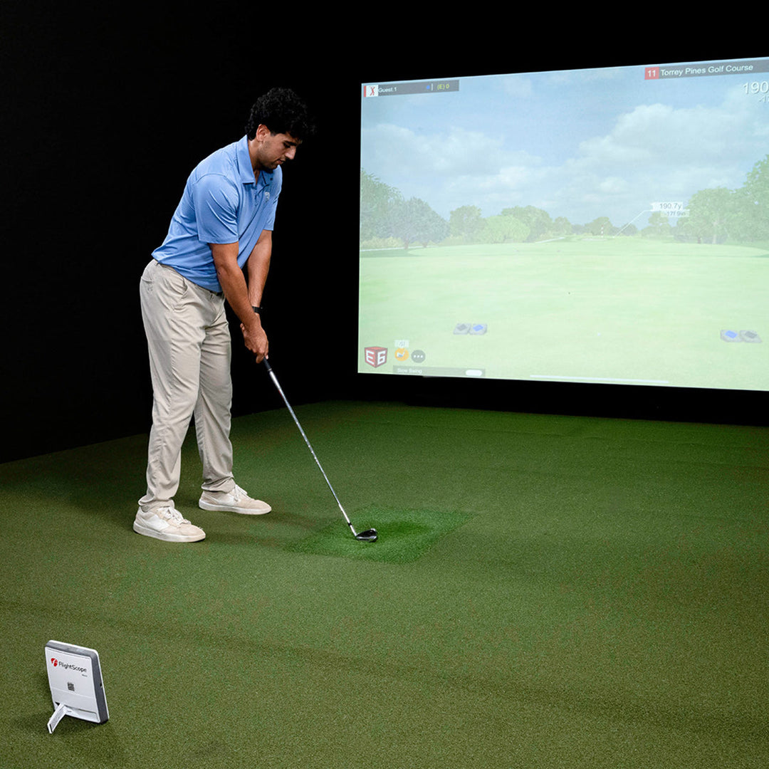 Golfer practicing indoors using FlightScope Mevo Gen2 with golf simulator projection – Golf & Greens