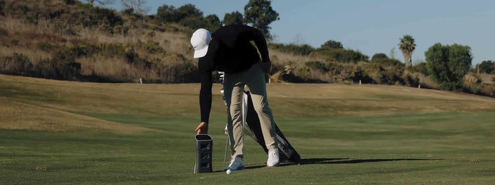 Golfjoy Spica 3 PLUS — golfeur positionnant le launch monitor près de la balle en extérieur