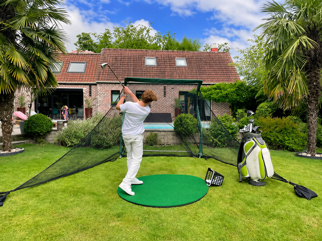 Golfer practising with the Practice Net Pro and side barriers in a garden; round hitting mat and golf bag sold separately