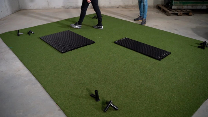 Parts and frame sections laid out for assembling the GolfBays SimBox golf simulator enclosure – available at Golf and Greens