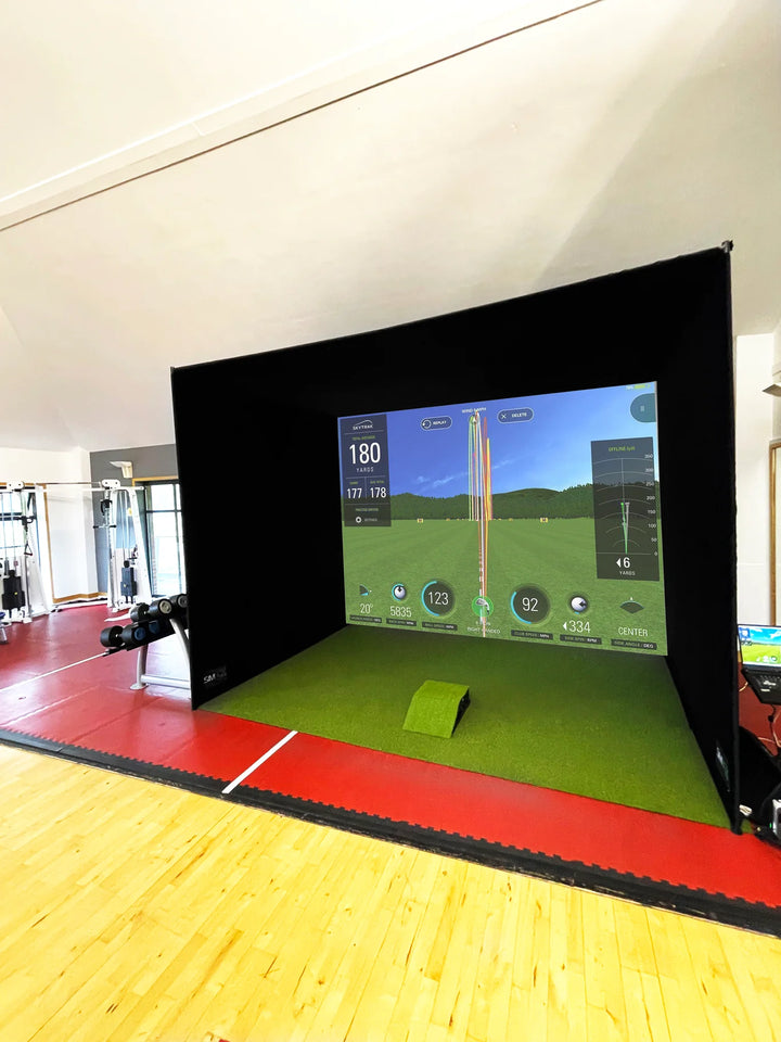 GolfBays SimBox golf simulator enclosure side view showing impact screen and launch monitor setup – available at Golf and Greens